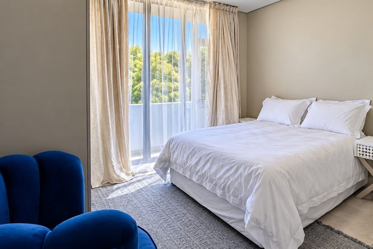 A bright and well-maintained bedroom featuring a large sliding glass door that provides natural light and access to an outdoor area.