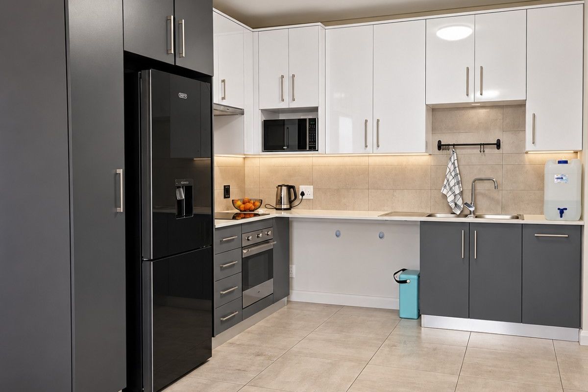 Modern kitchen featuring two-tone cabinetry, integrated appliances, sleek tiled backsplash, and high-quality finishes throughout.