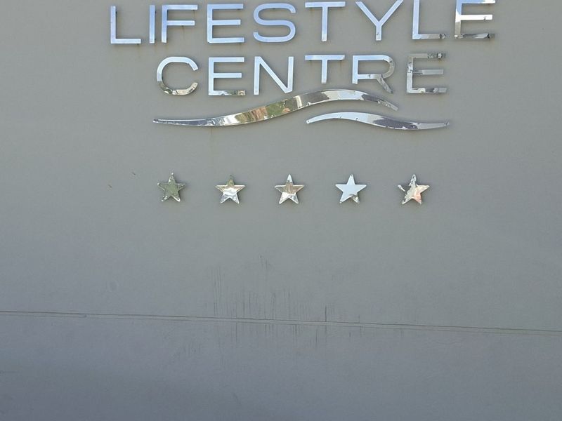 Exterior signage for the apartment complex lifestyle centre featuring metallic lettering and decorative star accents.