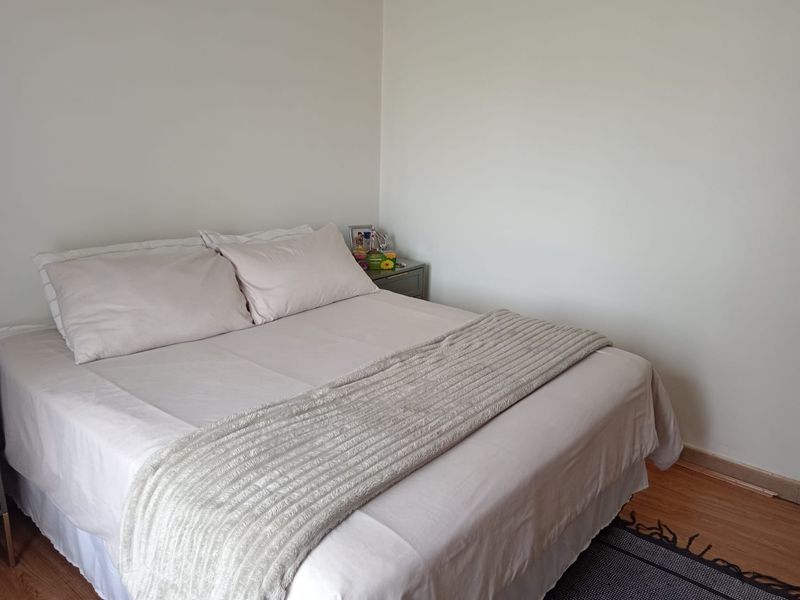 A simple bedroom featuring laminate flooring and neutral wall finishes, providing a clean and functional space.