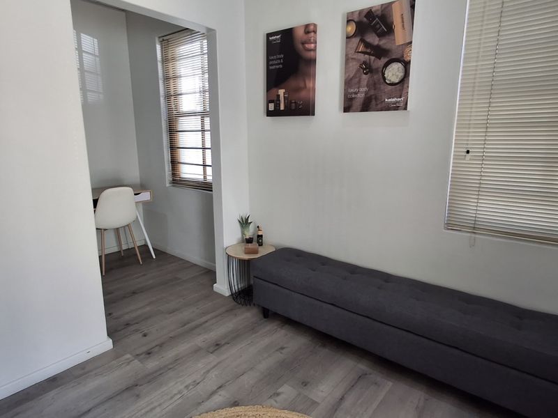 A bright office space featuring modern laminate flooring and venetian blinds, providing a clean and professional environment.