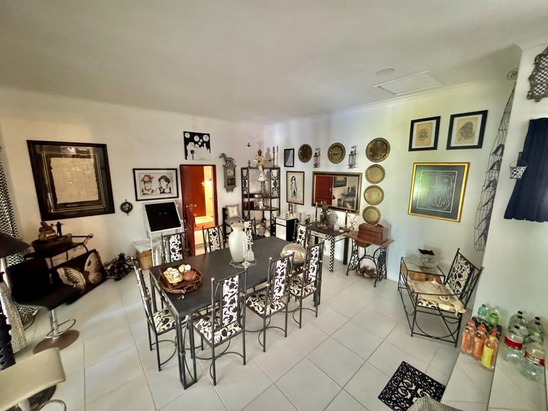A spacious dining area featuring neutral tiled flooring and a ceiling access hatch, providing a versatile space for family meals and entertaining.