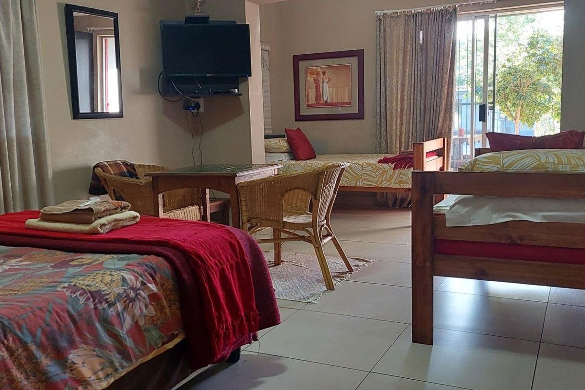 Spacious bedroom featuring tiled flooring and a sliding glass door providing access to the exterior.
