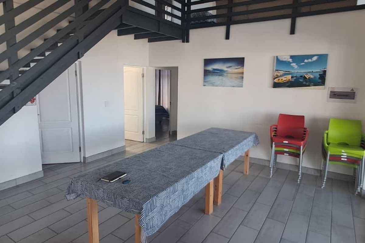 Open-plan living area featuring a staircase, tiled flooring, and sliding glass doors leading to the exterior.