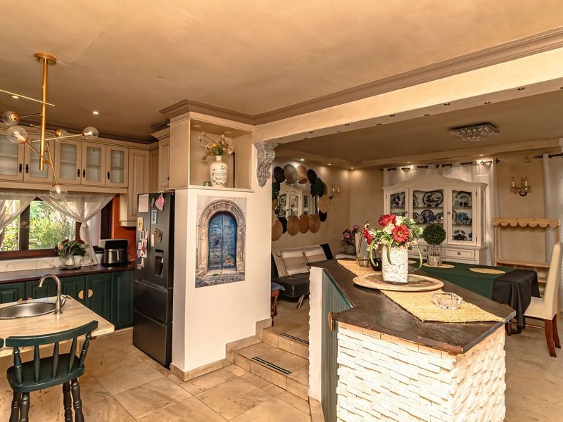 Spacious open-plan kitchen and dining area featuring a central island, brick-faced breakfast bar, and ample cabinetry, creating a functional and connected living space.