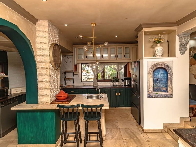 A characterful kitchen featuring dark green cabinetry, stone countertops, a unique stone feature wall, and a decorative archway, creating a warm and inviting space.