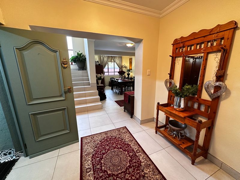 Welcoming entrance hall featuring tiled flooring and a staircase, providing a clear view into the open-plan living and dining area.