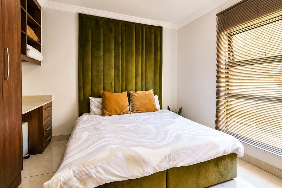 A well-maintained bedroom featuring built-in cabinetry, tiled flooring, and venetian blinds, providing a clean and functional living space.
