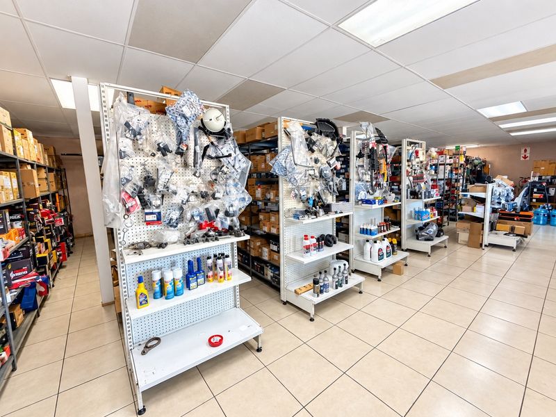 Commercial utility or storage space featuring suspended ceilings, tiled flooring, and multiple rows of metal shelving units for organized inventory management.