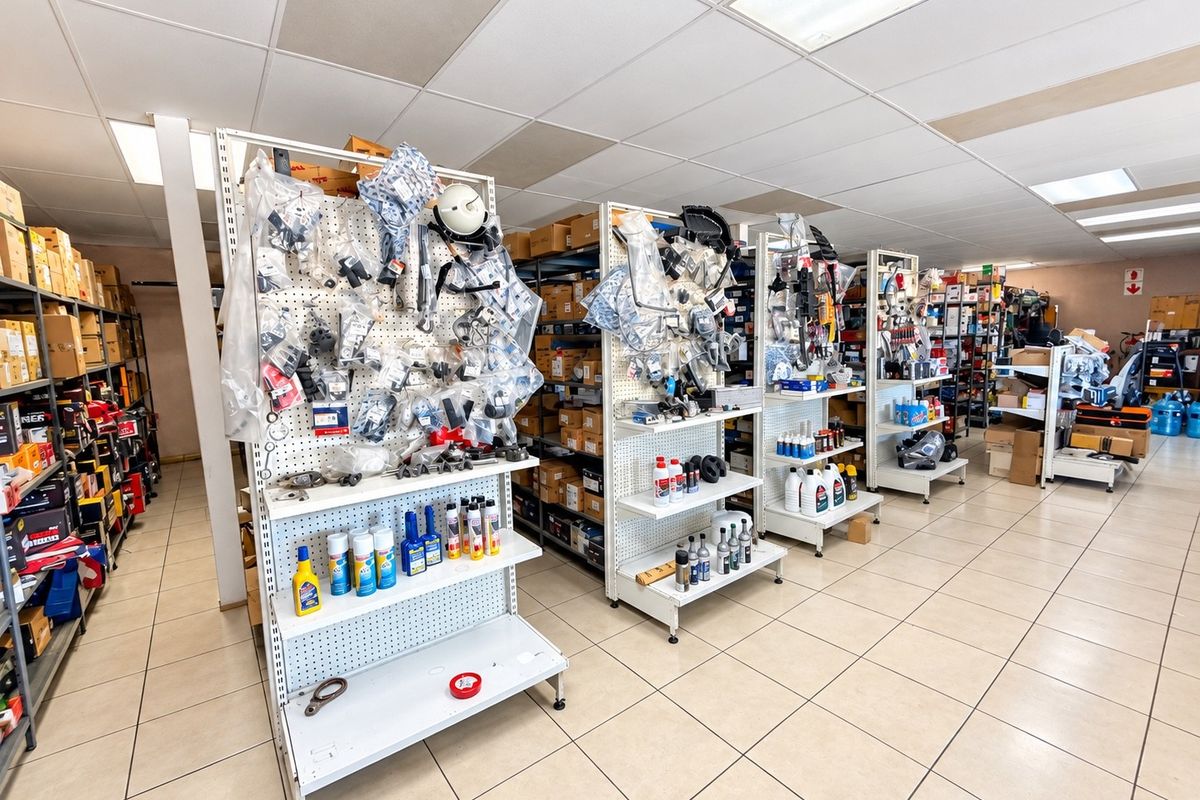 Commercial utility or storage space featuring suspended ceilings, tiled flooring, and multiple rows of metal shelving units for organized inventory management.