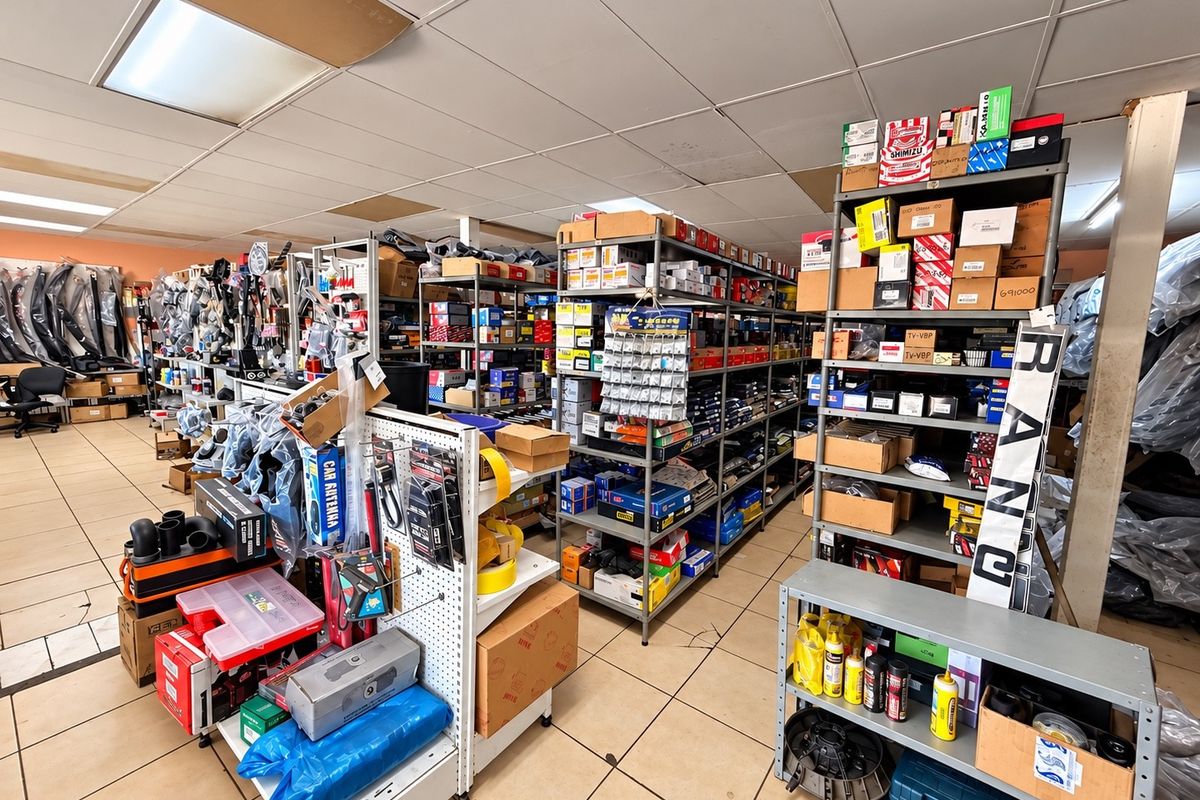 Commercial storage or retail space featuring industrial metal shelving units, suspended ceiling grid, and tiled flooring throughout.