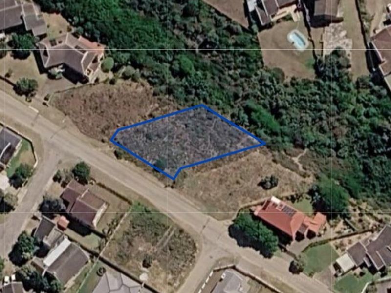 An aerial view of a vacant residential land plot outlined in blue, situated within an established suburban neighborhood.