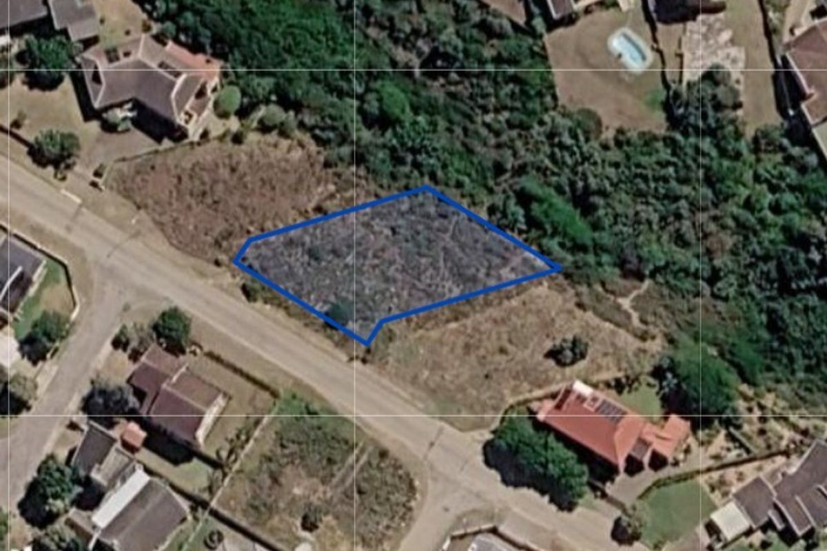An aerial view of a vacant residential land plot outlined in blue, situated within an established suburban neighborhood.