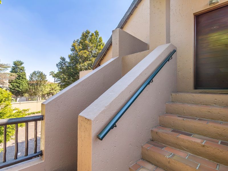 Exterior entrance featuring a masonry staircase with a handrail leading to a solid wood front door.