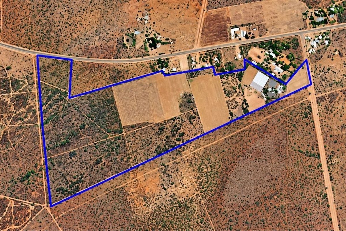 Aerial view of a large farm property showing the boundary lines, cultivated agricultural land, and existing farm infrastructure.
