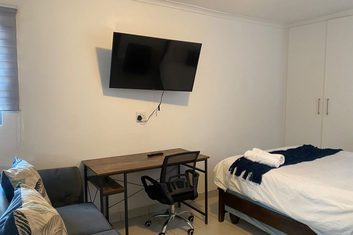 A functional bedroom featuring tiled flooring, a built-in wardrobe, and a roller blind, providing a practical and comfortable living space.