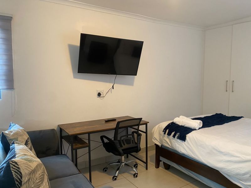 A functional bedroom featuring tiled flooring, a built-in wardrobe, and a roller blind, providing a practical and comfortable living space.