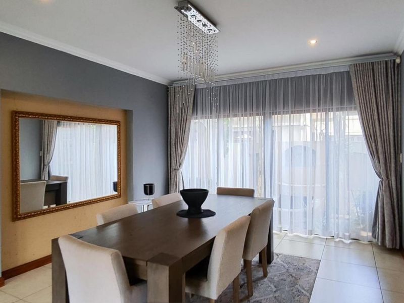 A well-lit dining room featuring tiled flooring, recessed lighting, and large sliding glass doors that provide ample natural light.