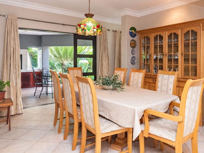 A dining room featuring tiled flooring, cove cornicing, and a built-in display cabinet, with direct access to an outdoor patio area.