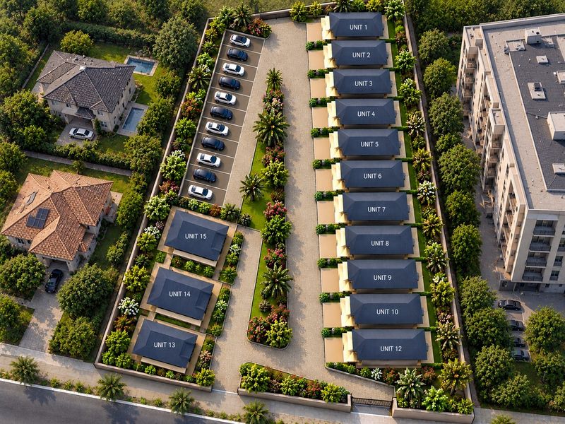 Aerial view of a residential complex featuring multiple detached units, landscaped gardens, paved driveway, and designated parking areas within a secure perimeter.