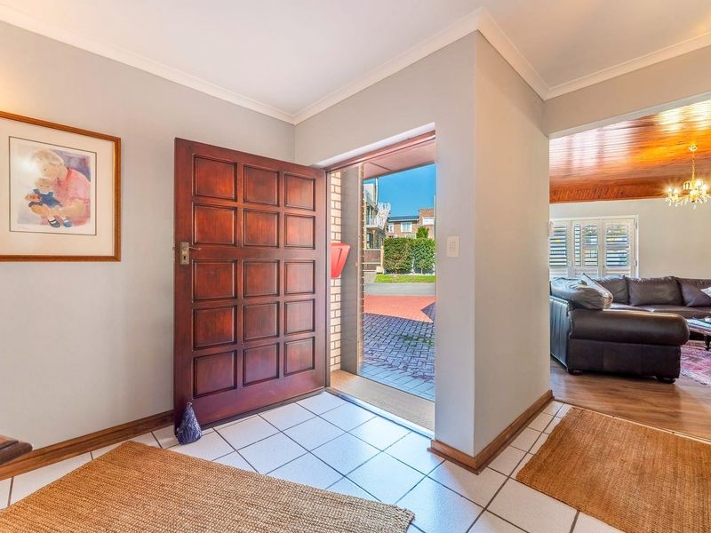 Welcoming entrance hall featuring tiled flooring and a solid timber panelled front door, providing direct access to the main living area.