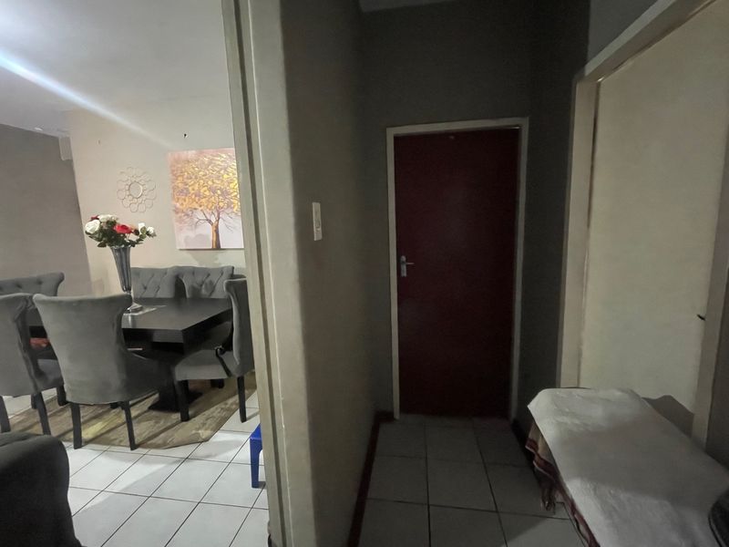 A functional hallway area with tiled flooring connecting to the adjacent living and dining space.