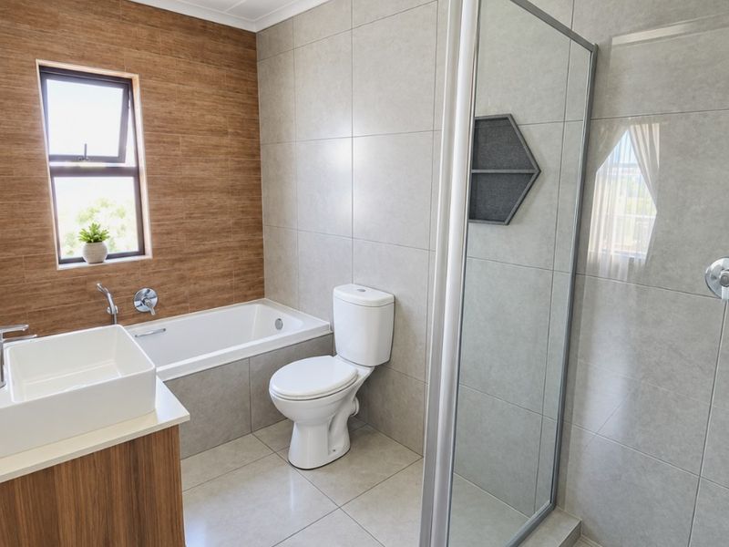 Modern bathroom featuring a glass-enclosed shower, built-in bathtub, wall-mounted vanity with basin, and contemporary neutral tiling.