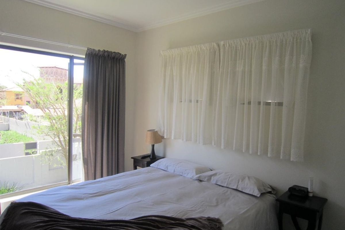 A bedroom featuring a sliding glass door with access to an outdoor area and neutral wall finishes.