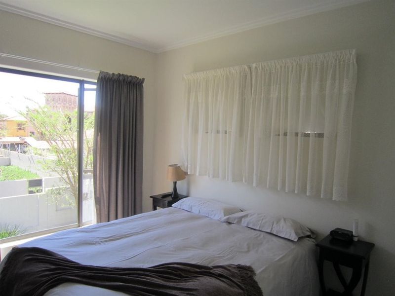 A bedroom featuring a sliding glass door with access to an outdoor area and neutral wall finishes.