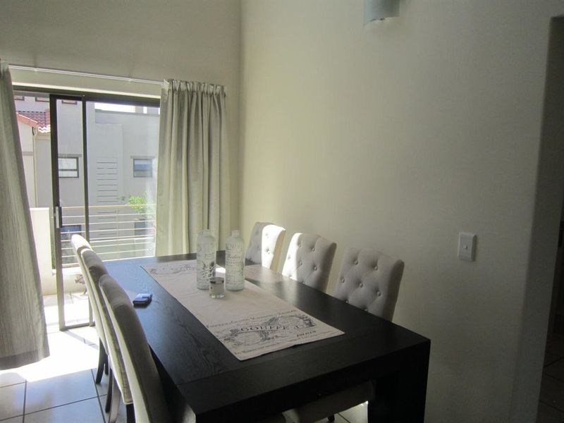 A dining area featuring tiled flooring and a sliding glass door that provides access to an outdoor balcony.