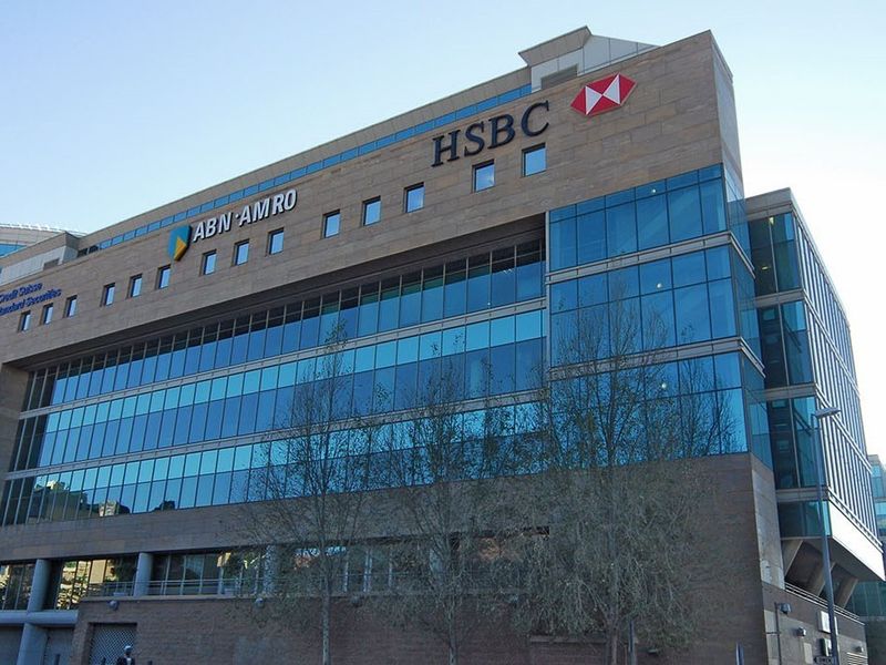A modern multi-story commercial office building featuring a glass curtain wall facade and prominent corporate signage.