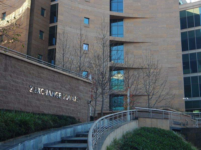Exterior view of 2 Exchange Square featuring a modern stone facade, glass curtain walling, and a landscaped entrance staircase with stainless steel railings.