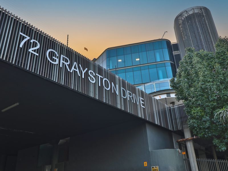 Modern commercial building facade at 72 Grayston Drive featuring a striking vertical louvre design and contemporary glass curtain wall architecture.