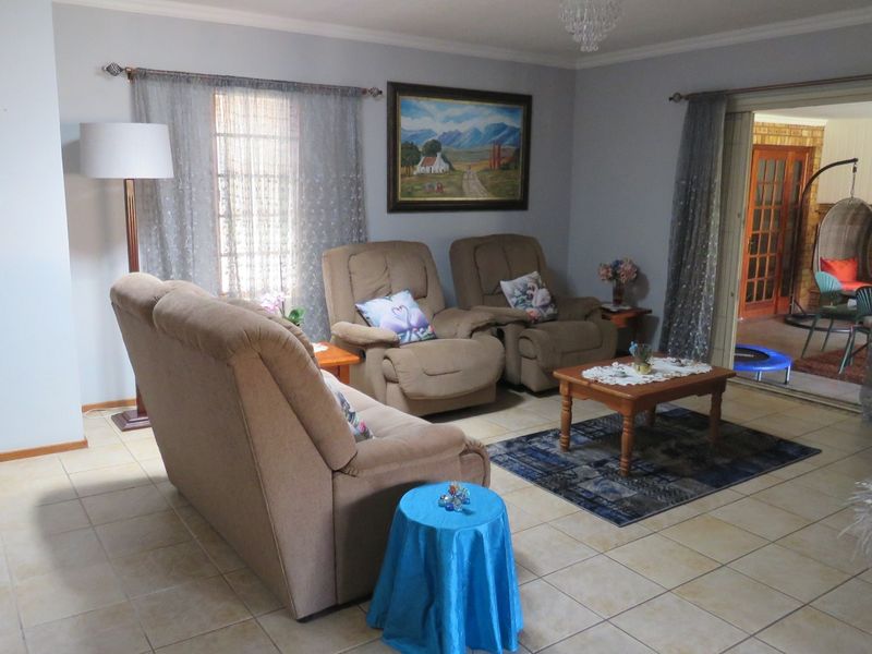 A comfortable living room featuring neutral tiled flooring and a sliding glass door providing access to an adjacent patio area.