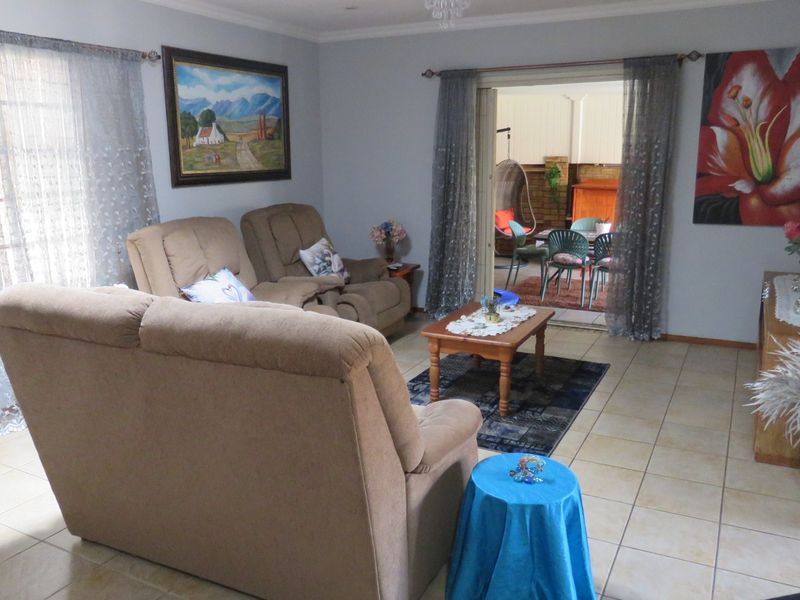 A comfortable living room featuring tiled flooring and sliding glass doors that provide access to an outdoor patio area.