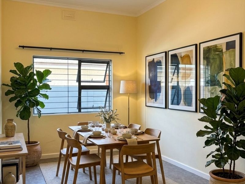 A bright and well-maintained dining room featuring modern lighting, tiled flooring, and a large window with aluminium frames.