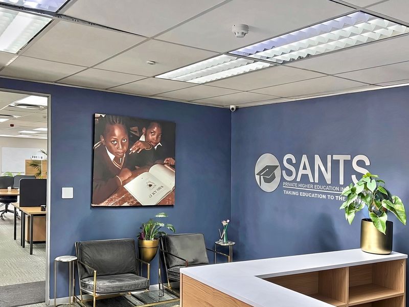 Professional commercial reception area featuring a branded wall, built-in reception desk, and suspended ceiling with integrated lighting.