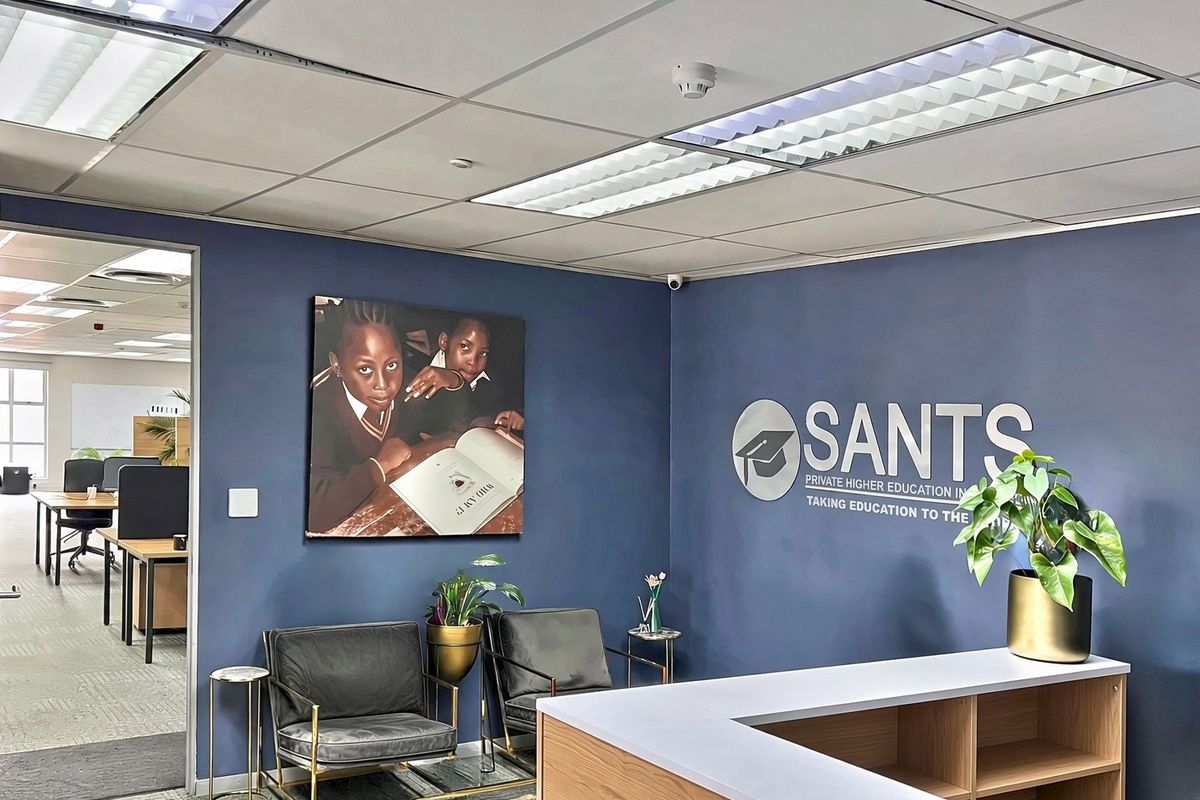 Professional commercial reception area featuring a branded wall, built-in reception desk, and suspended ceiling with integrated lighting.