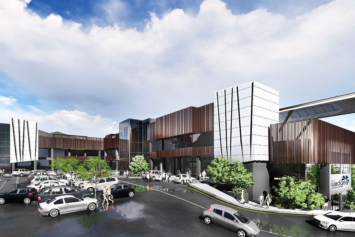A modern commercial building exterior featuring contemporary metal cladding, glass facades, and an integrated parking area.