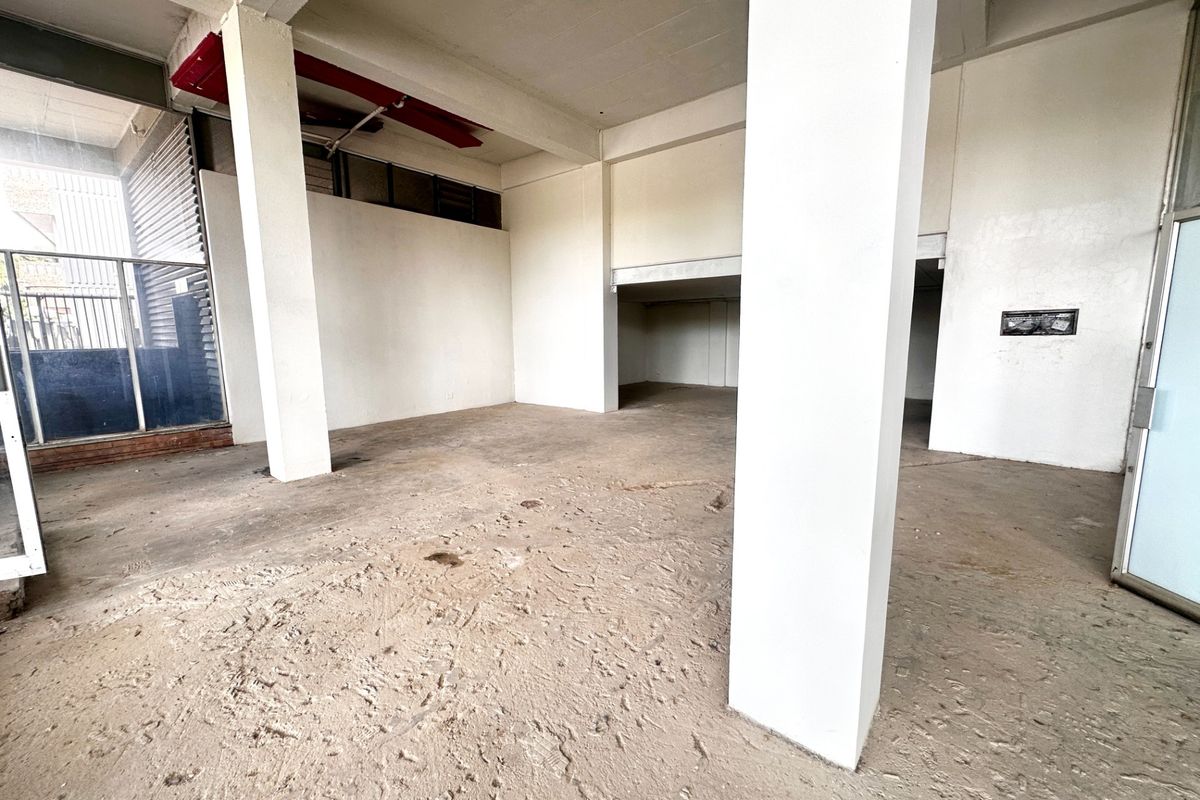 An expansive, empty commercial open-plan space featuring exposed concrete flooring, structural columns, and high ceilings, suitable for a variety of business fit-outs.