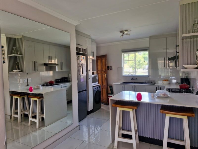 Modern kitchen featuring sleek cabinetry, stone countertops, a functional island with seating, and integrated appliances, finished with polished floor tiles.