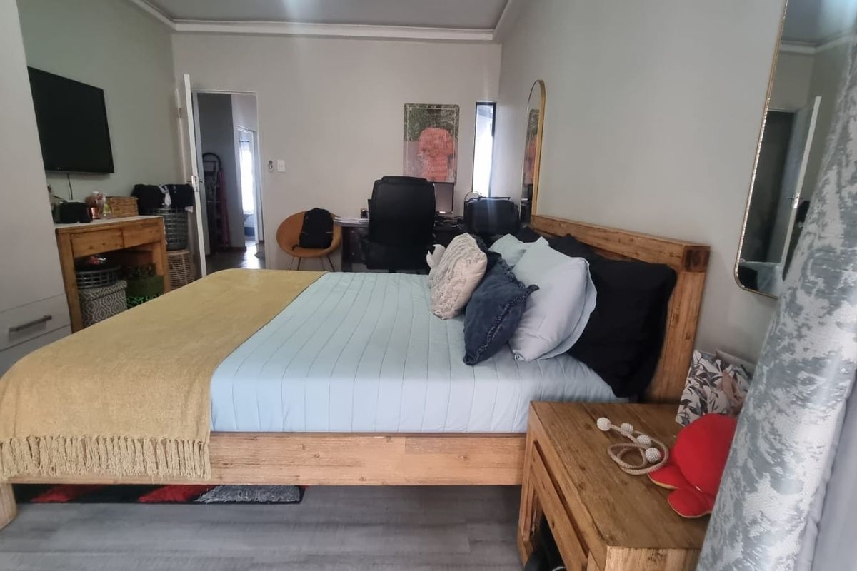 A functional bedroom featuring laminate flooring and a built-in wardrobe, offering a comfortable and practical living space.