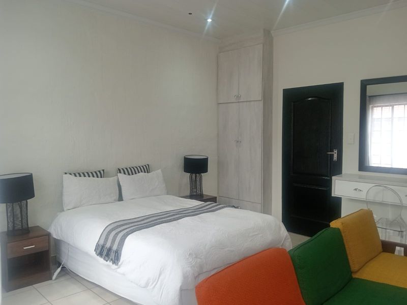 A bedroom featuring tiled flooring, recessed downlighting, and a built-in cupboard with a neutral finish.