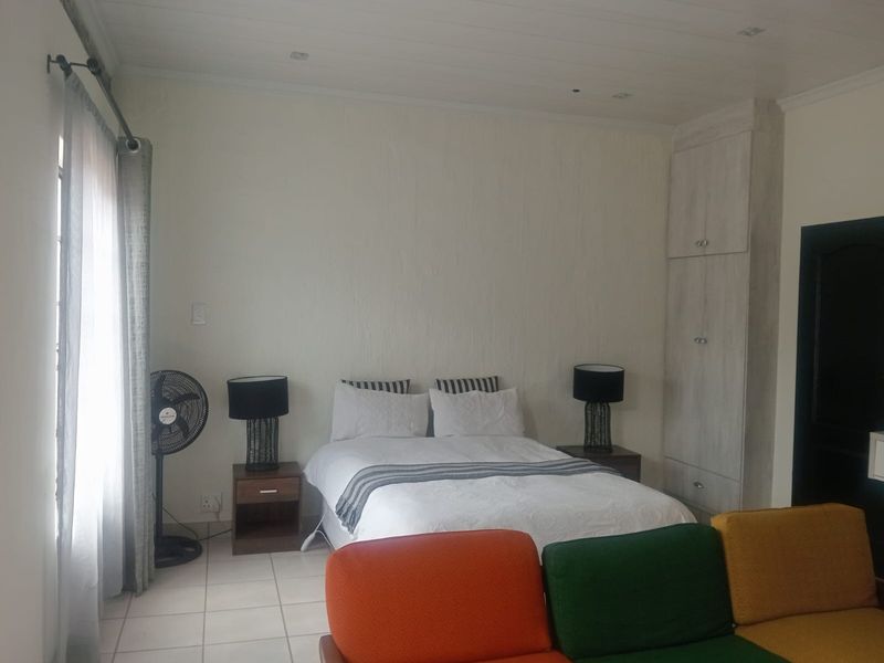 A bedroom featuring tiled flooring, recessed ceiling lighting, and a built-in wardrobe with light wood-grain finish.