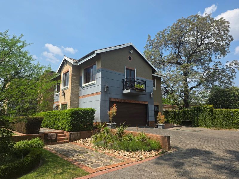 A well-maintained double-story residential property featuring a paved driveway, integrated double garage, and a private balcony with wrought iron detailing.