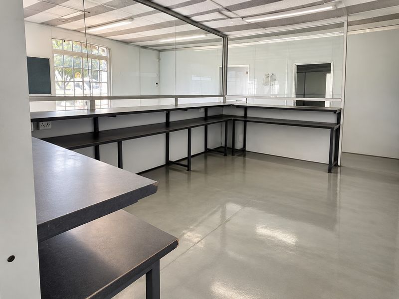 Open plan retail or office space featuring durable epoxy flooring, built-in service counters, and glass partitions for a clean, professional layout.