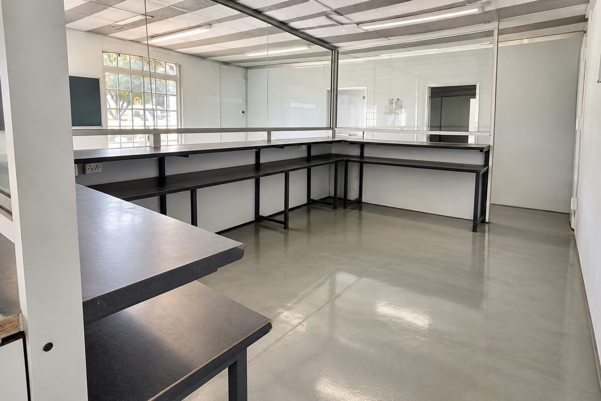 Open plan retail or office space featuring durable epoxy flooring, built-in service counters, and glass partitions for a clean, professional layout.