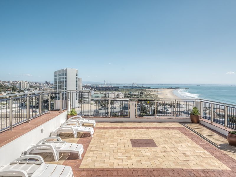 Spacious rooftop balcony featuring a paved terrace, metal balustrades, and panoramic coastal and city views.