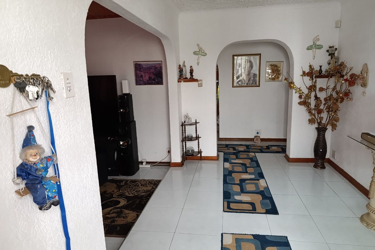 A living area featuring distinctive arched doorways, white walls, and tiled flooring, providing a neutral foundation for potential interior updates.