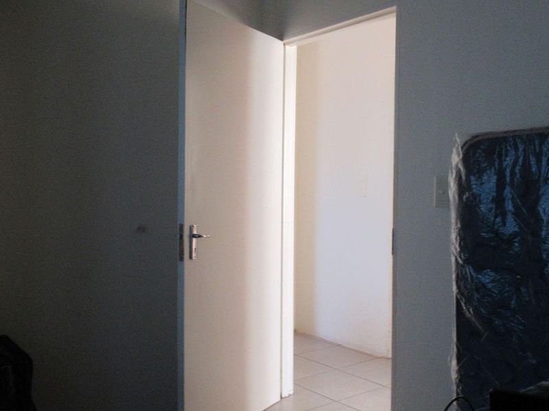 A view through an open doorway into a tiled hallway area.